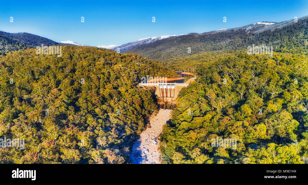 Gumtree coloratissimi boschi intorno Guthega diga sul fiume nevoso in montagne innevate durante periodi freddi della stagione invernale quando acqua è bloccato nel serbatoio da d Foto Stock