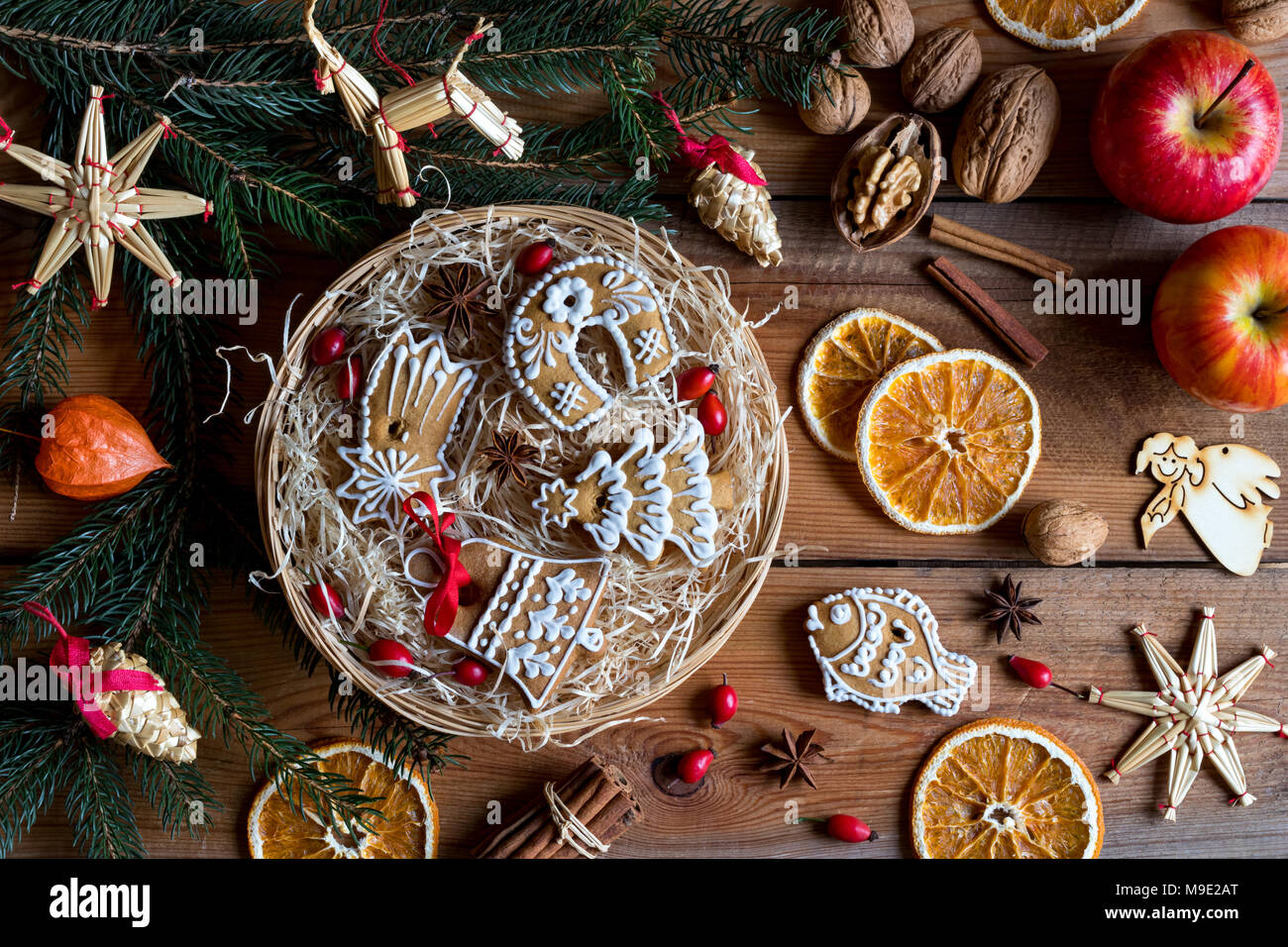 Natale decorati gingerbread cookie in un round cesto in vimini, con rami di abete rosso, ornamenti di paglia, mele, noci, cannella, anice stellato, rose h Foto Stock