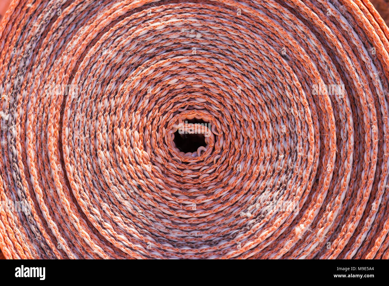 Rotolo di plastica arancione nastro di costruzione. Motivo decorativo Foto Stock