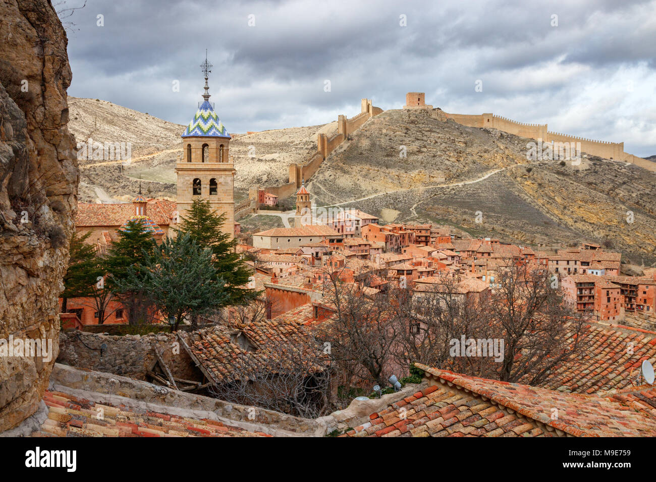Bellissima vista della città medievale Albarracin con le colline e le mura della città sullo sfondo sotto un cielo nuvoloso. Teruel, Spagna. Foto Stock