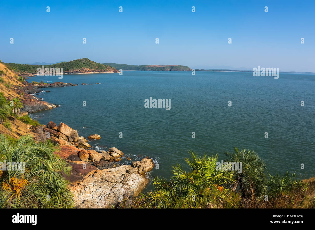 Il panorama è bellissimo litorale roccioso, il blu del mare e cielo senza nuvole in Om beach, Gokarna, Karnataka, India Foto Stock