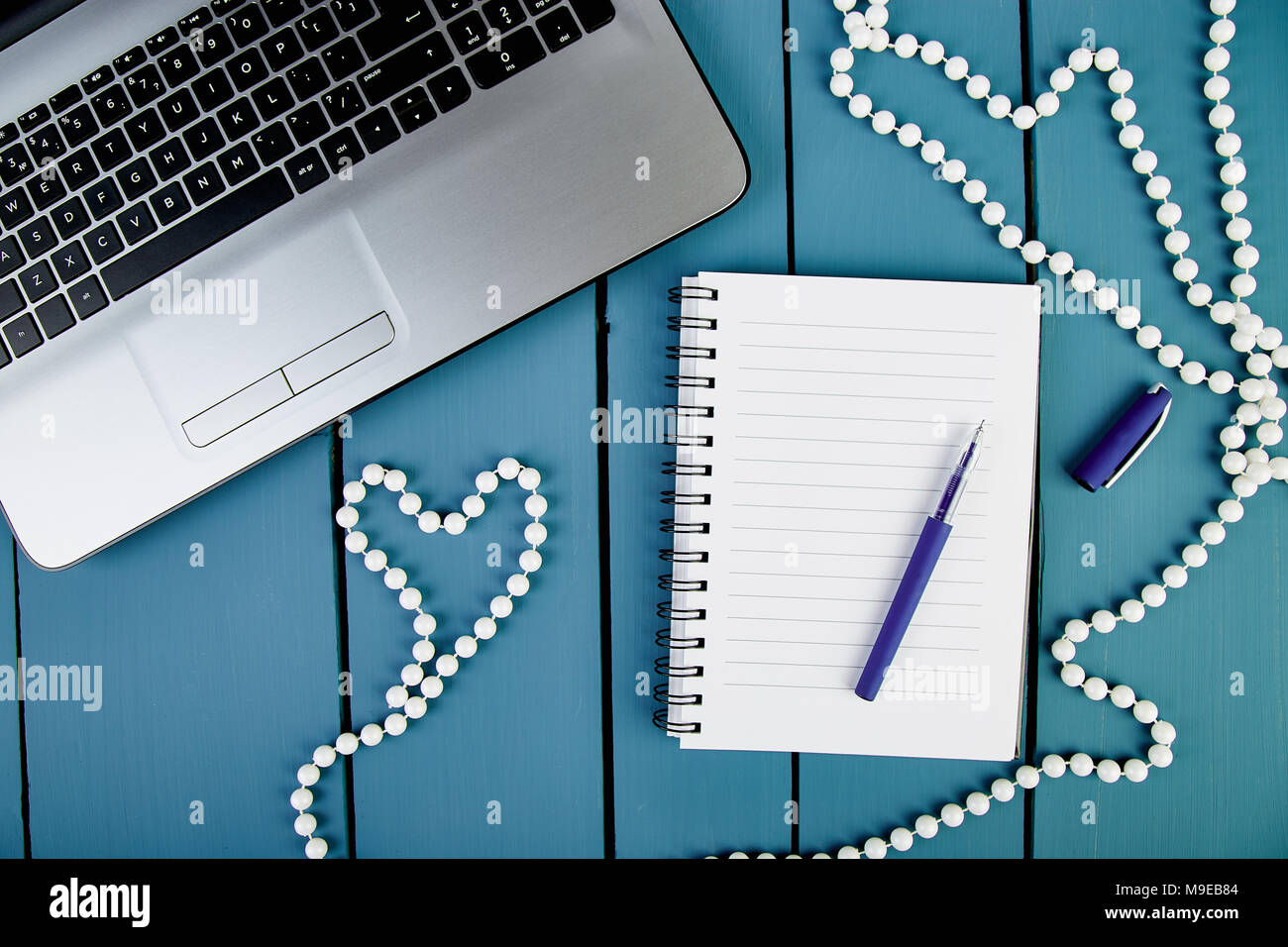 Le donne moderne workplace con notebook o computer portatile. Still Life, business, forniture per ufficio o il concetto di istruzione. Lay piatto. Vista dall'alto. Il simbolo Cuore, l'amore. Foto Stock