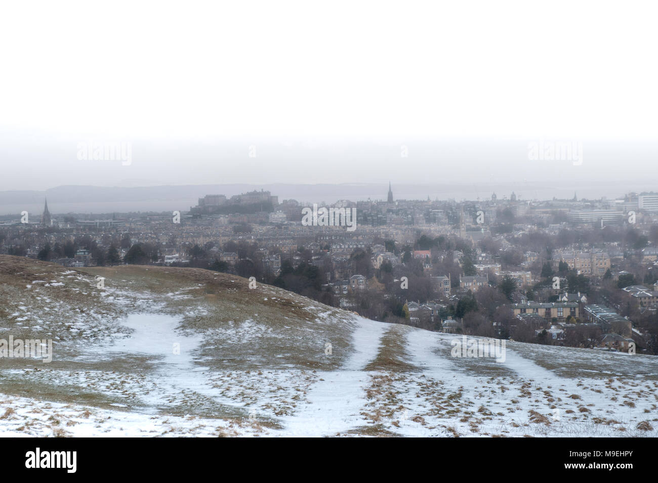 Una vista dall'alto sopra di Edimburgo in mezza luce con il Castello di Edimburgo e King Arthur' Seat in background Foto Stock