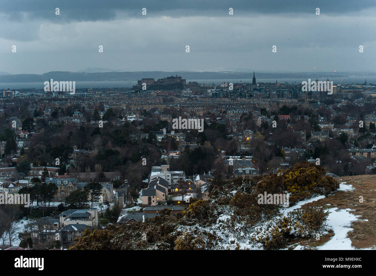 Una vista dall'alto sopra di Edimburgo in mezza luce con il Castello di Edimburgo e King Arthur' Seat in background Foto Stock