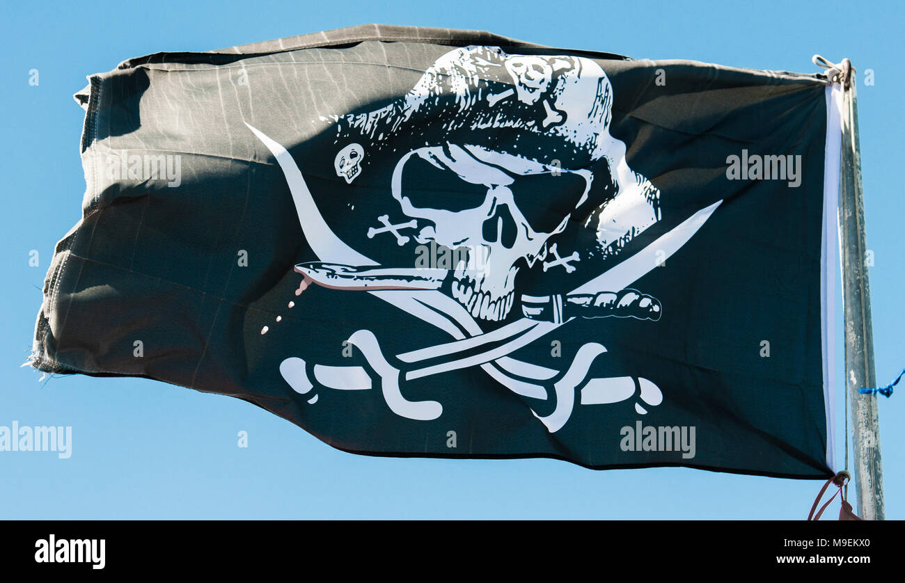 Bianco e nero cranio e crossbones pirate flag su un pennone. Foto Stock
