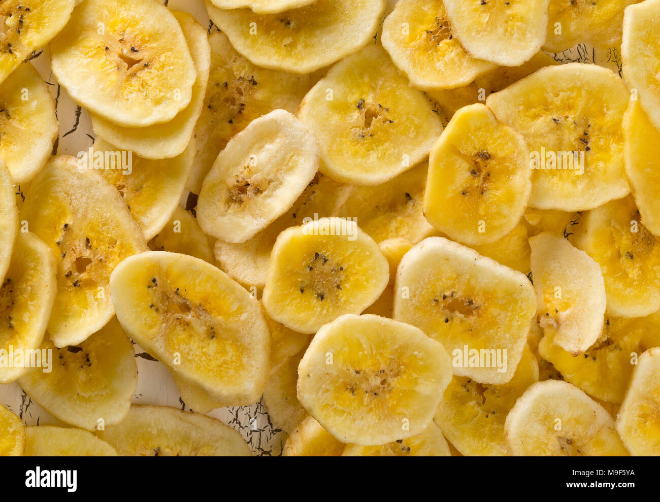 Cumulo di Banane essiccate chips snack su bianco tavolo rustico vista superiore Foto Stock
