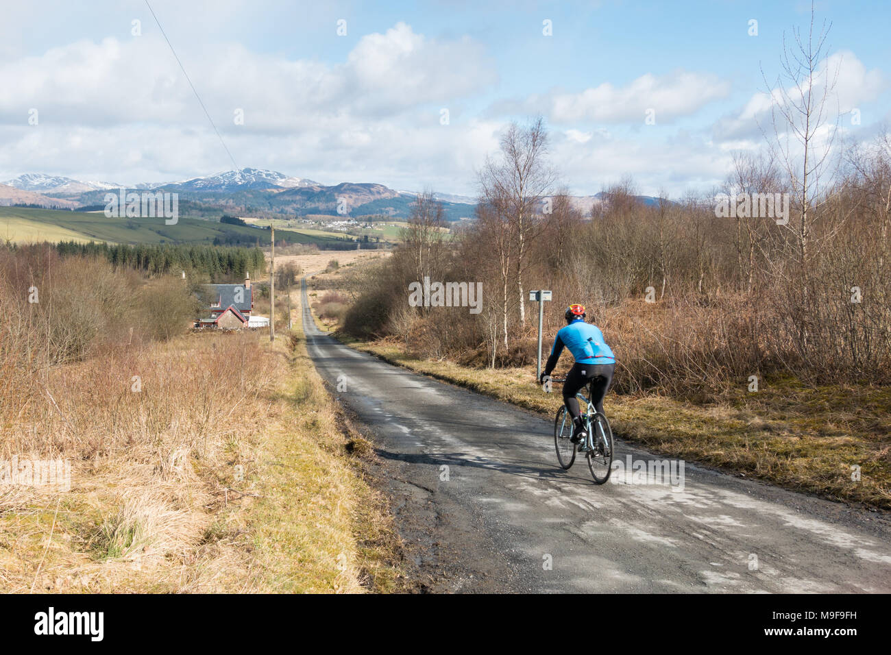 Ciclista sul ciclo nazionale Route 7, Old Drymen Road da Drymen dirigendosi verso Gartmore, Stirling, Scozia, Regno Unito Foto Stock