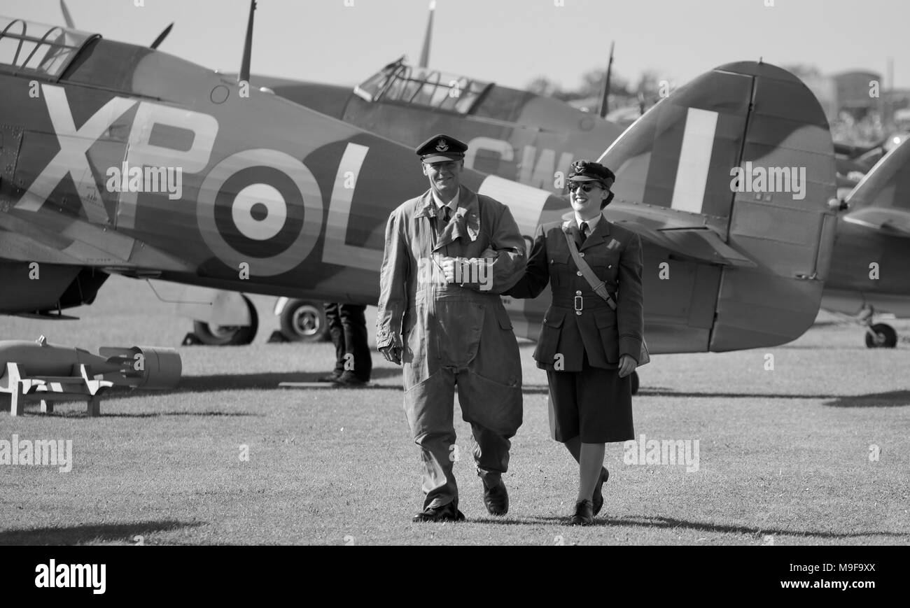 Un paio in periodo di abbigliamento con Hawker Hurricane essere505 nel retro terra a Duxford Battaglia di Airshow di Gran Bretagna Foto Stock