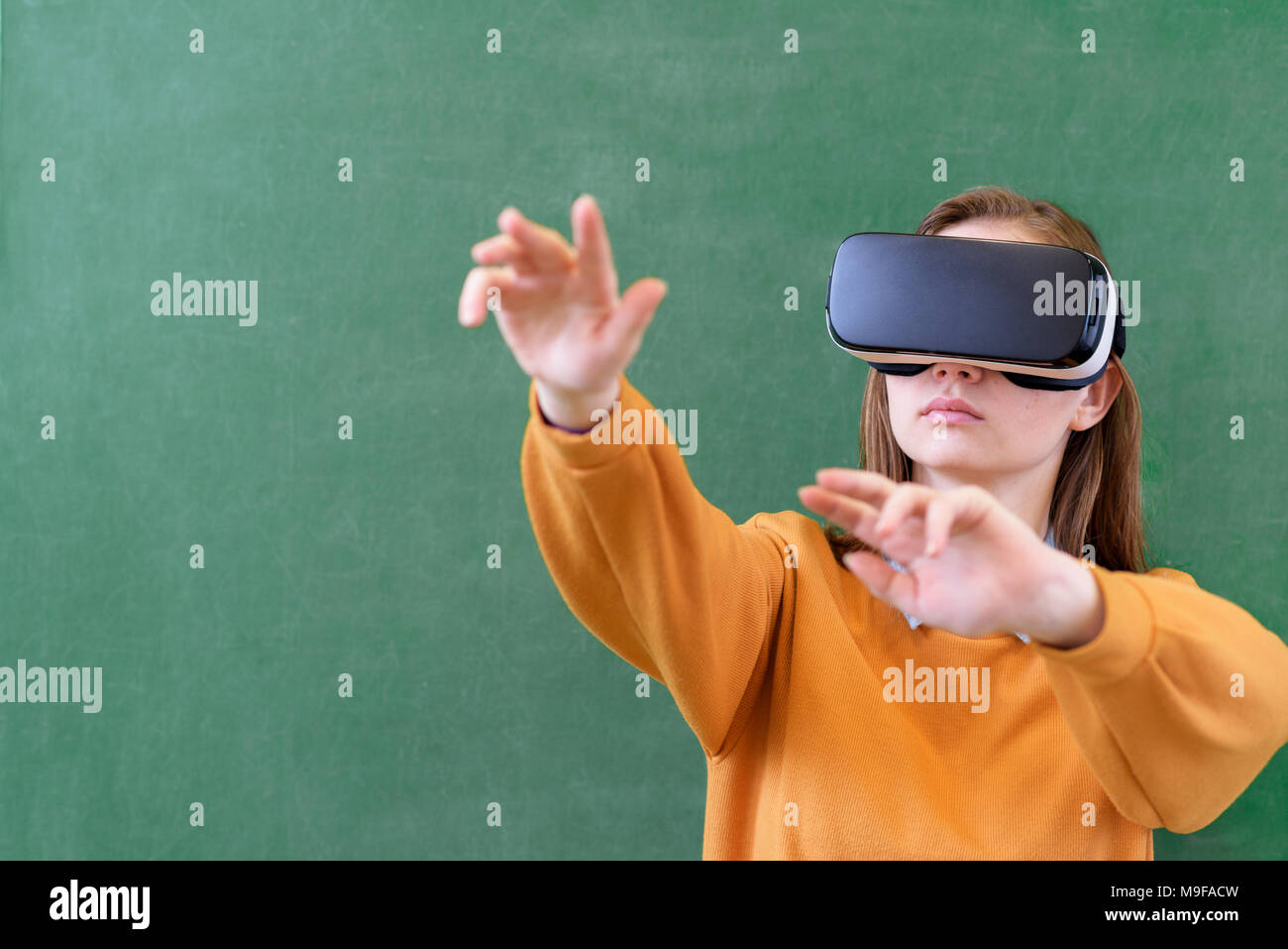 Adolescente studentessa indossando occhiali per realtà virtuale in aula a scuola. Metodi di insegnamento innovativi. Il concetto di istruzione. Foto Stock