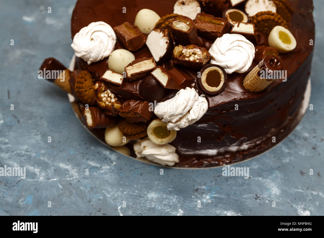 Una festosa torta al cioccolato decorata con un corno di cialda, dolci di  cioccolato, marshmallows, biscotti su uno sfondo scuro Foto stock - Alamy