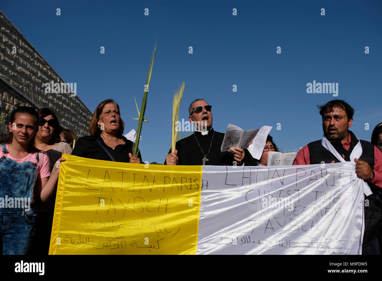 Gerusalemme, Israele 25 marzo. 2018. I cristiani arabi dalla città palestinese di Taybeh in Cisgiordania prendendo parte al tradizionale Domenica delle Palme processione dal Monte degli Ulivi per il quartiere cristiano di Gerusalemme la città vecchia, il giorno che segna per i cristiani Gesù Cristo lâ entrata in Gerusalemme quando i suoi seguaci di cui rami di palma nel suo percorso, prima della sua crocifissione e segna l'inizio della Settimana Santa, che termina sulla Pasqua. Foto Stock