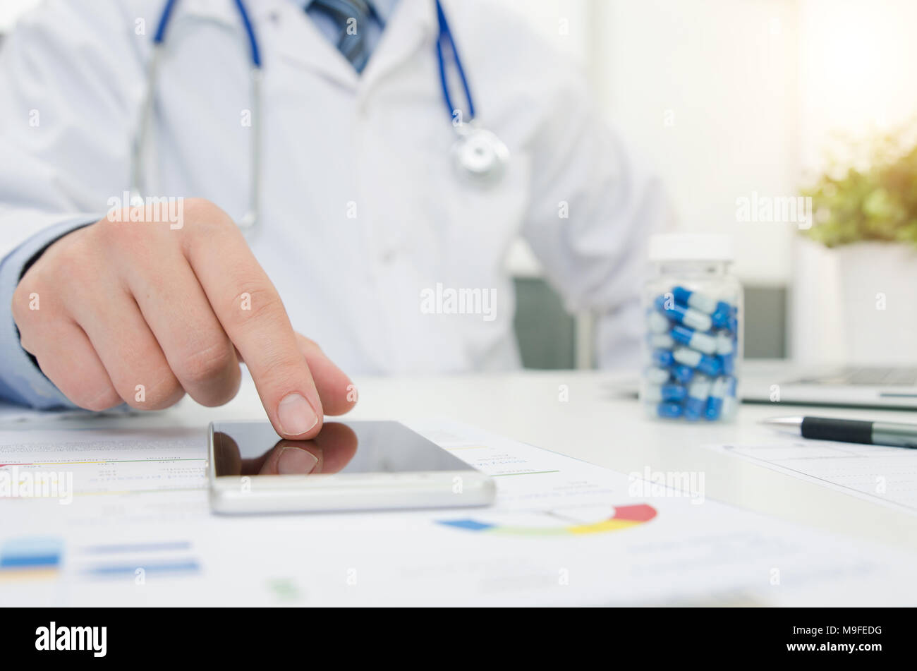Medico che lavorano con il telefono e il computer portatile in ospedale o in clinica. Delle cure mediche concept Foto Stock