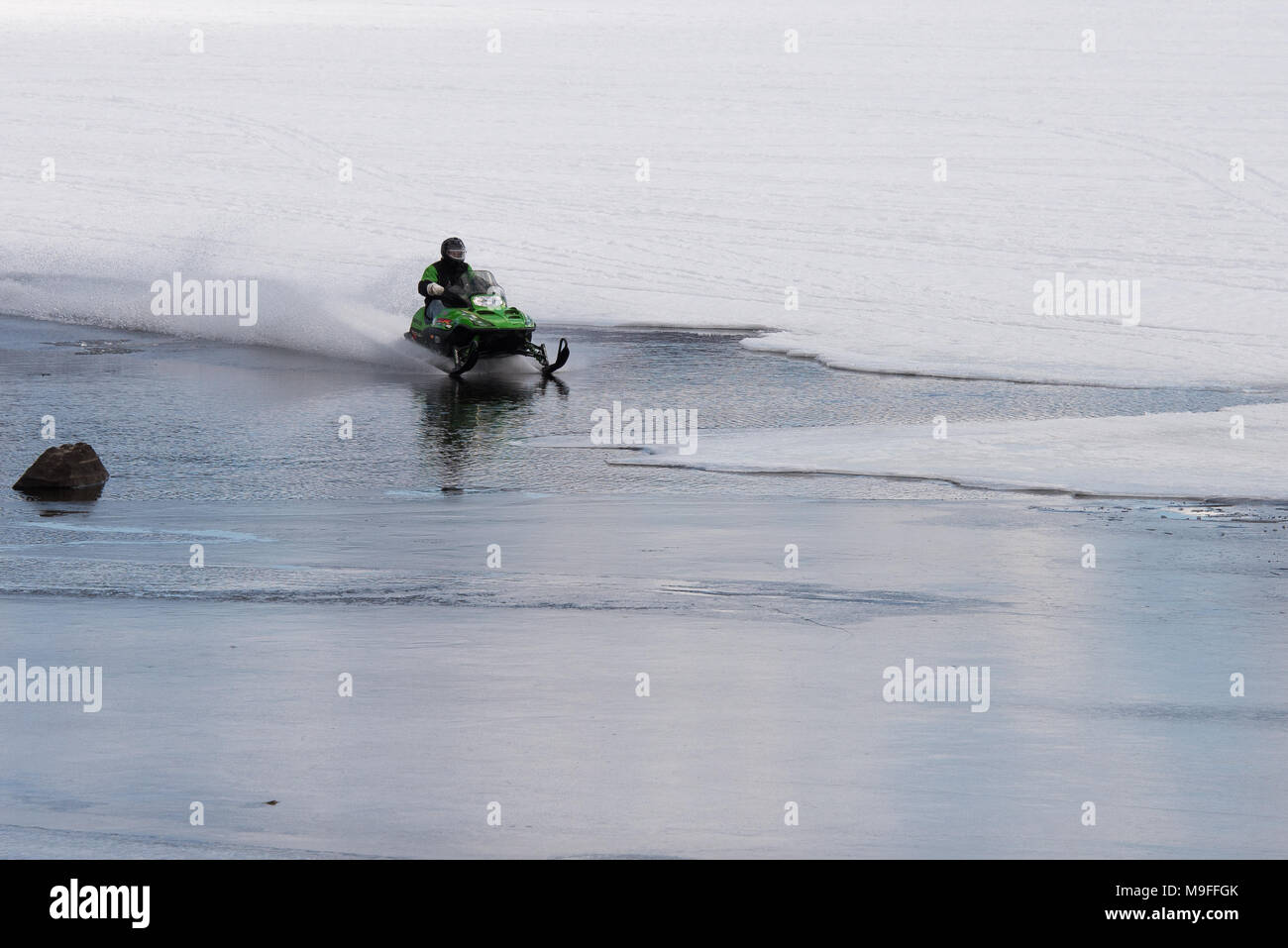 In Snowmobile racing attraverso una patch aperto di acqua sul Lago Pleasant, NY nelle Montagne Adirondack, con copia spazio. Foto Stock