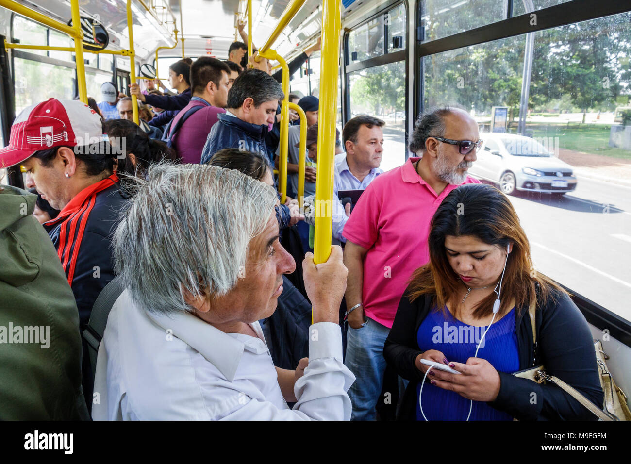 Buenos Aires Argentina,bus,passeggeri passeggeri riders,in piedi,uomo uomini maschio,donna donne donne,in piedi,ascoltare,auricolari,ispanico,ARG171128221 Foto Stock