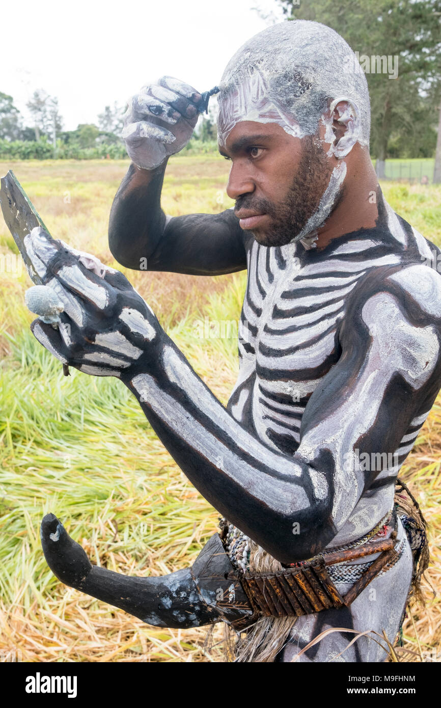 Un Omo scheletro Masilal uomo si prepara per il Mount Hagen spettacolo culturale, Papua Nuova Guinea Foto Stock