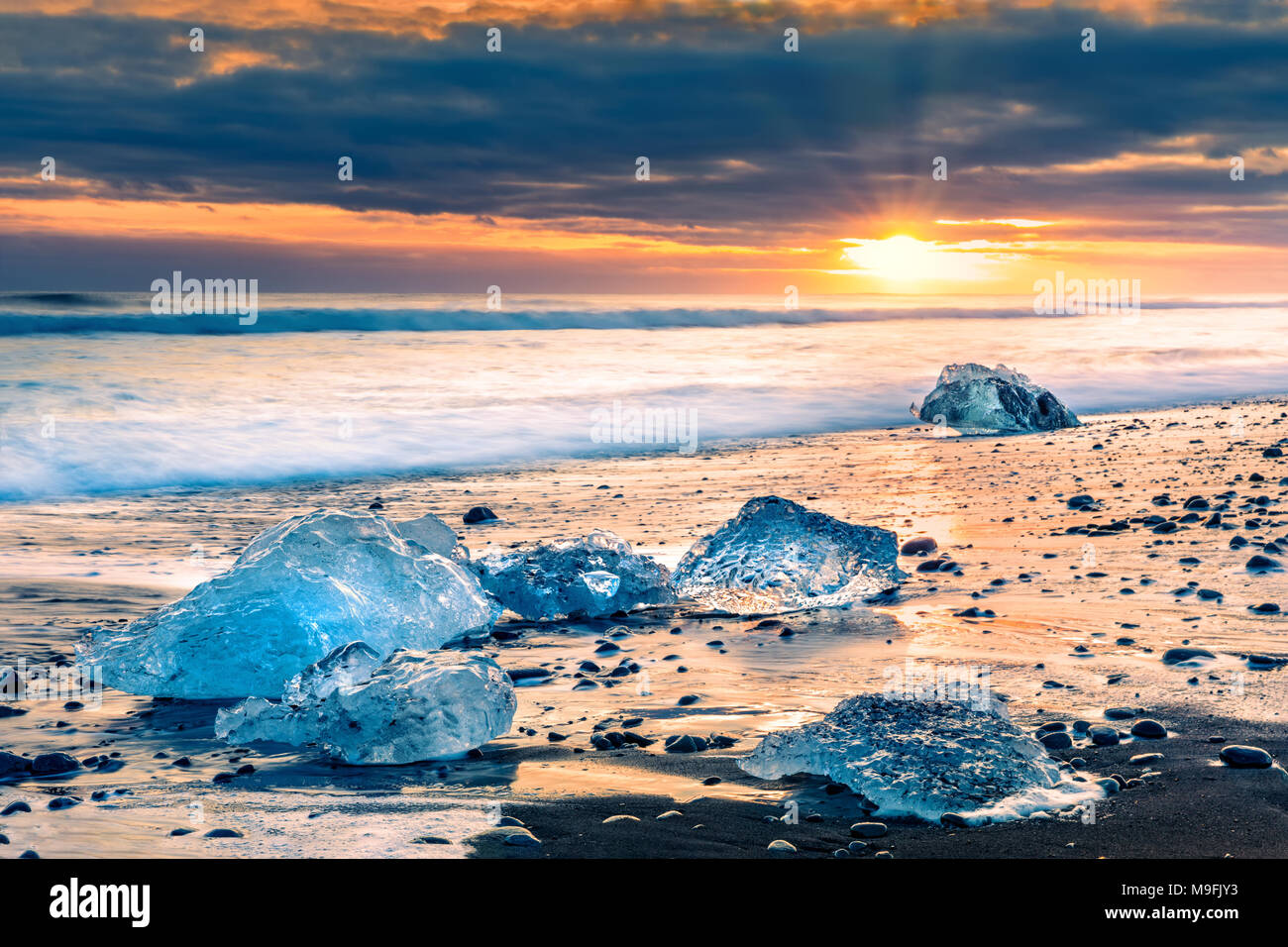 Il drifting blocchi di ghiaccio sulla spiaggia di diamante, al tramonto, in Jokulsarlon, Islanda Foto Stock