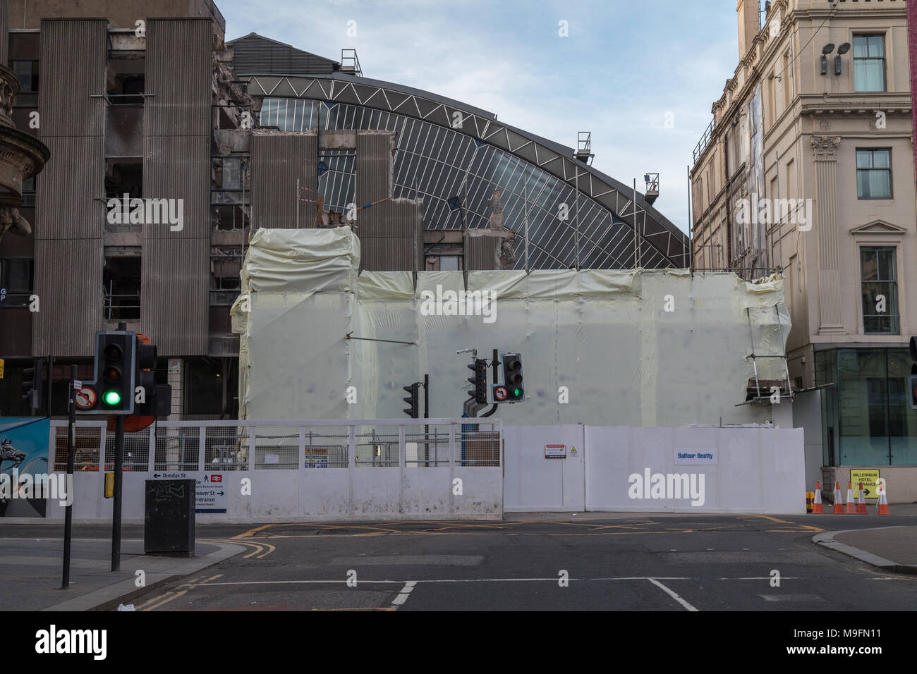 Il precedentemente nascosti anteriore in vetro della stazione di Glasgow Queen Street è parzialmente visibile ancora come l'edificio di fronte è demolito Foto Stock