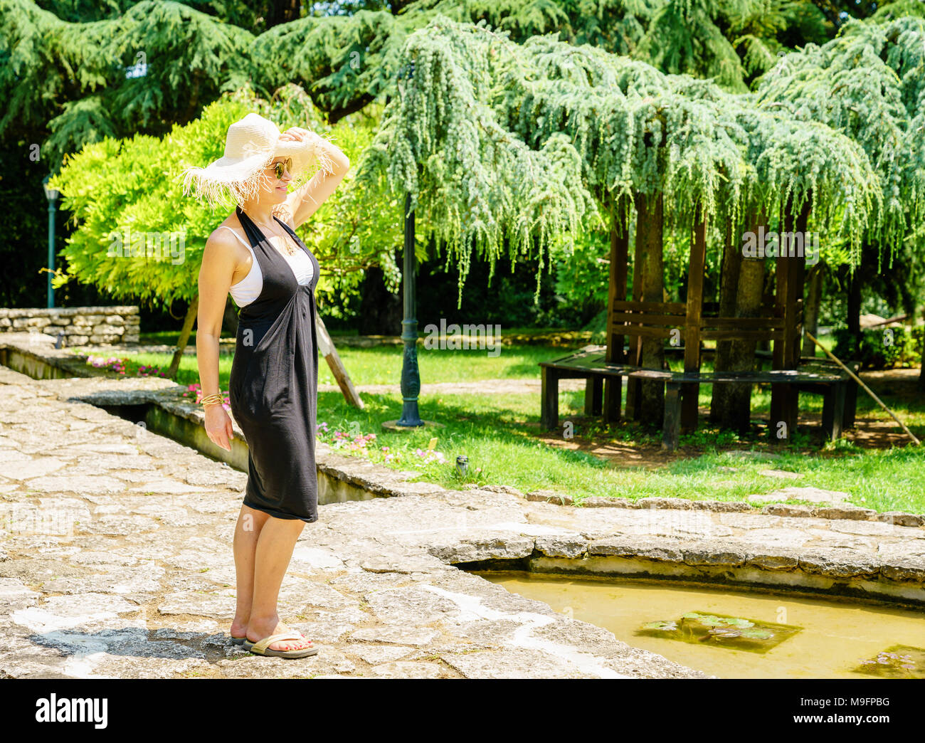 Felice bella donna sta godendo di giorno di estate in un giardino Foto Stock