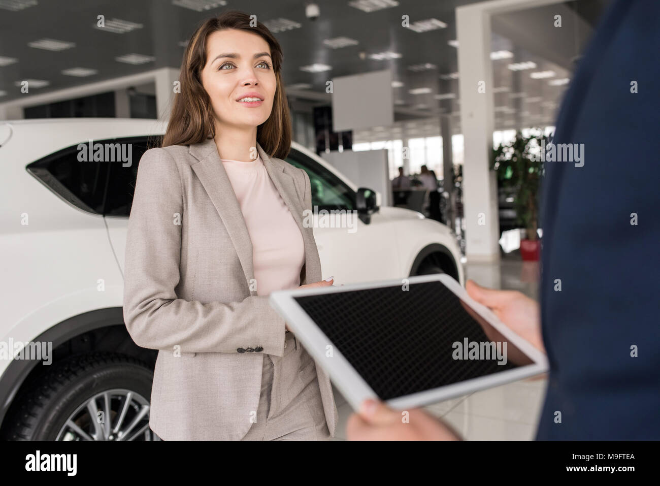 Bella Donna che parla al venditore in showroom Foto Stock