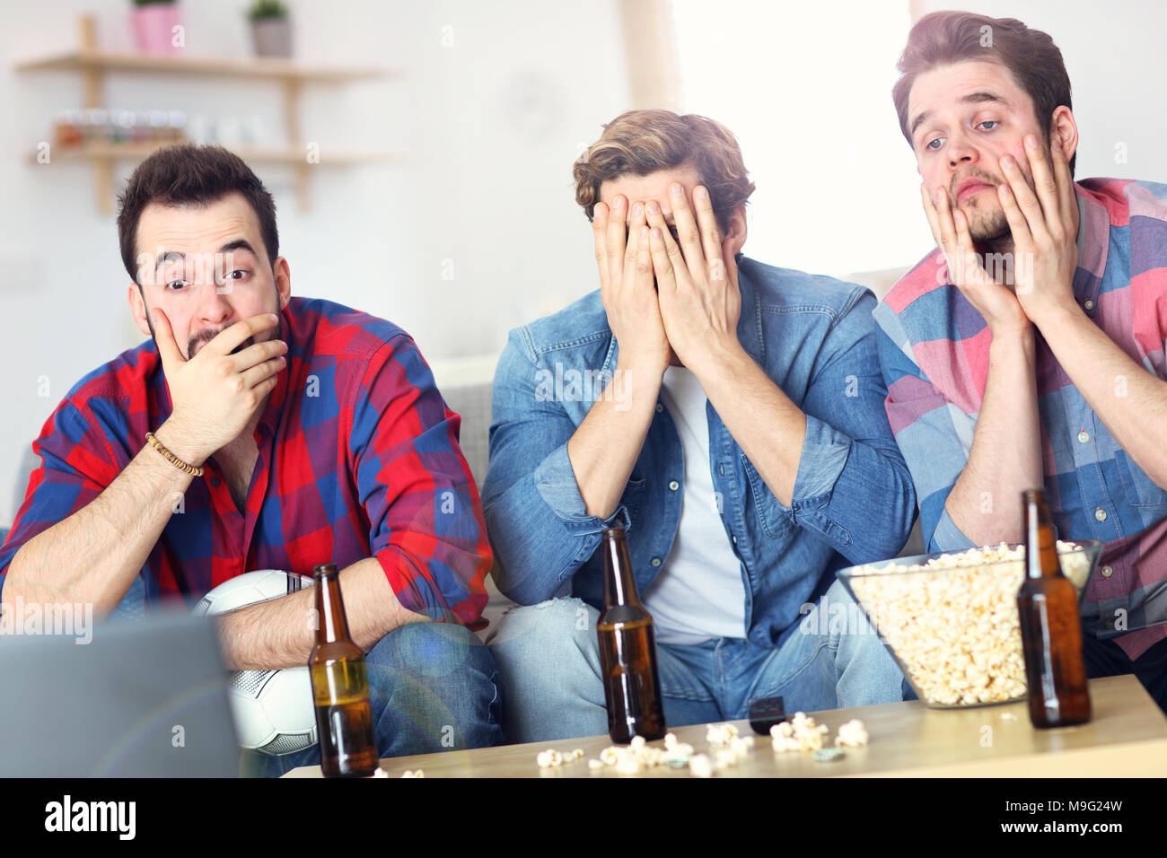 Immagine del triste amici maschi a guardare lo sport in tv a casa Foto Stock