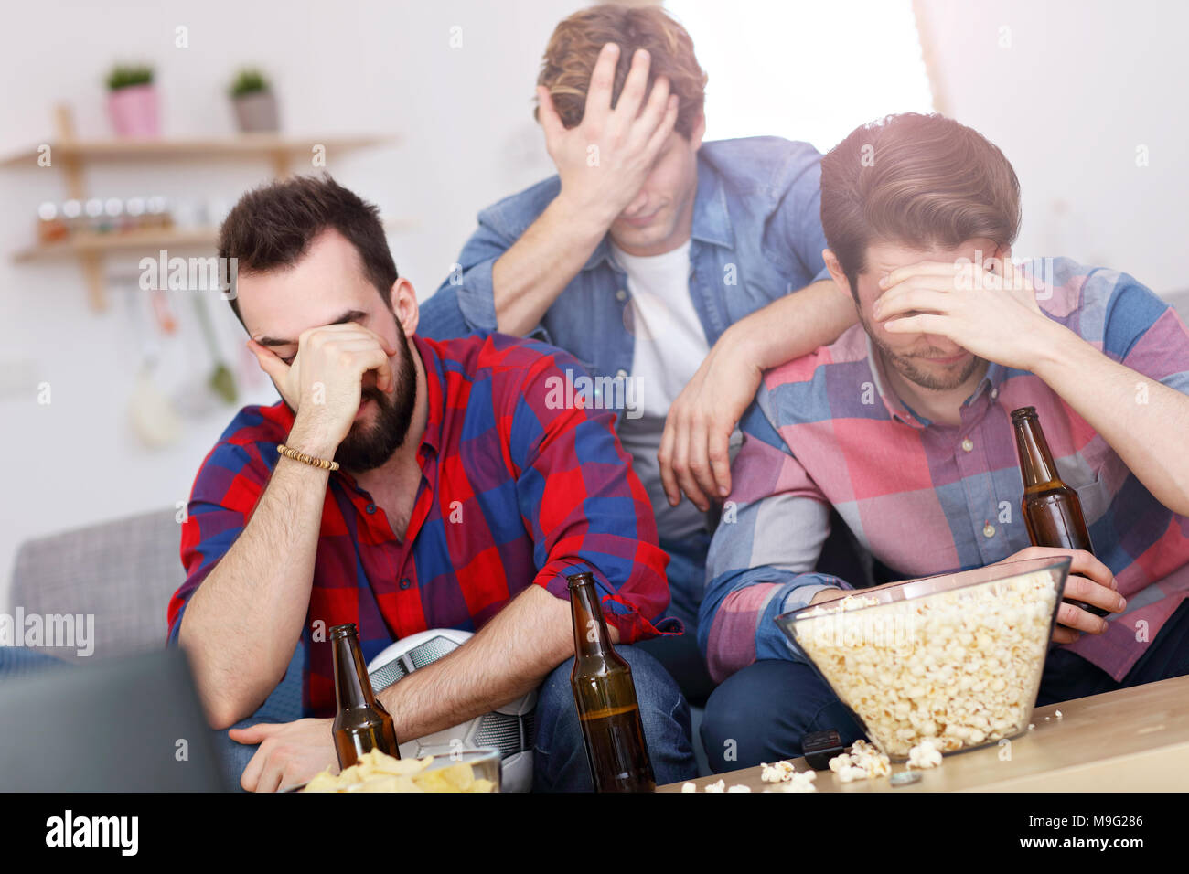Immagine del triste amici maschi a guardare lo sport in tv a casa Foto Stock