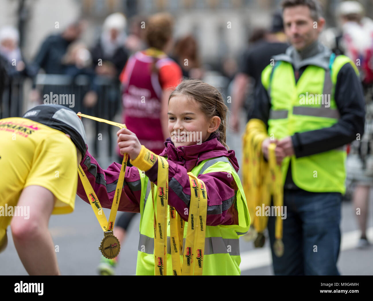 Londra, Regno Unito. Xxv Marzo 2018. Bambina aiutando dare medaglie a Londra - La Mezza Maratona di credito: Keith Donegan/Alamy Live News Foto Stock