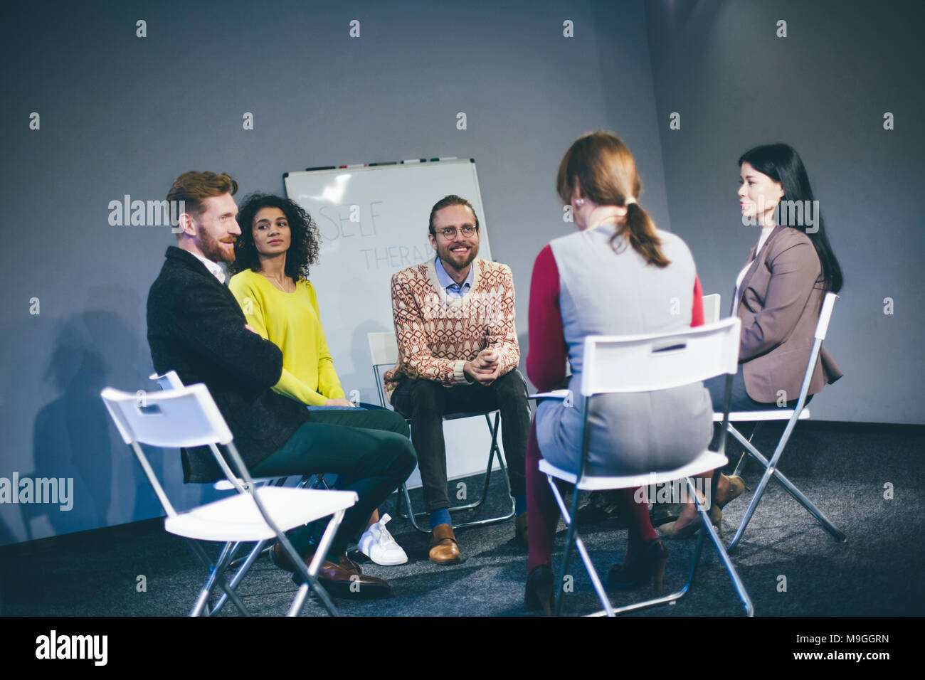 Un folto gruppo di persone aventi una sessione di consulenza. Foto Stock