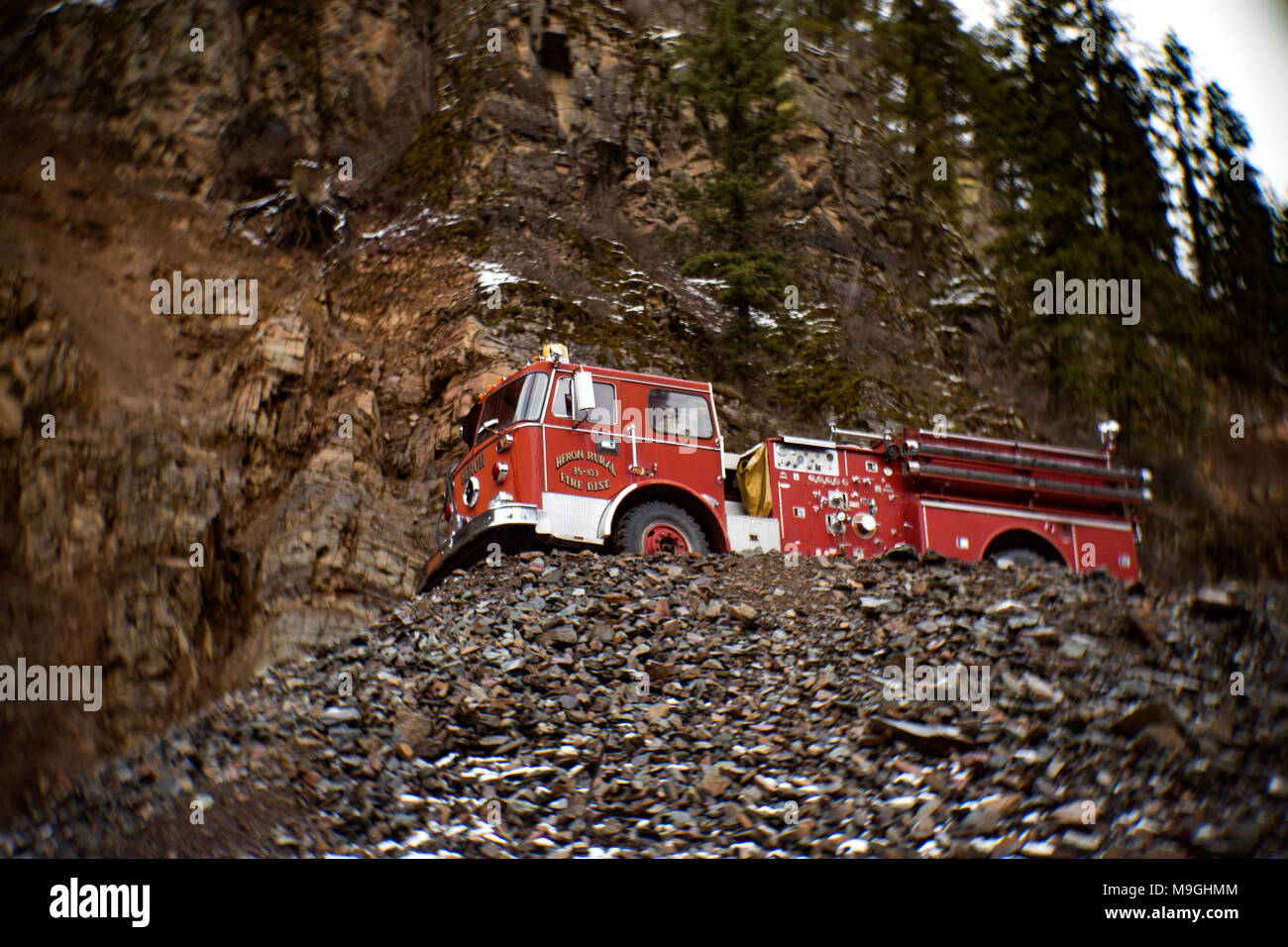 Un rosso 1974 Western Star mansarda camion dei pompieri sulla sommità di una pila di rocce, in una vecchia cava di pietra, a est di Clark Fork Idaho. Foto Stock