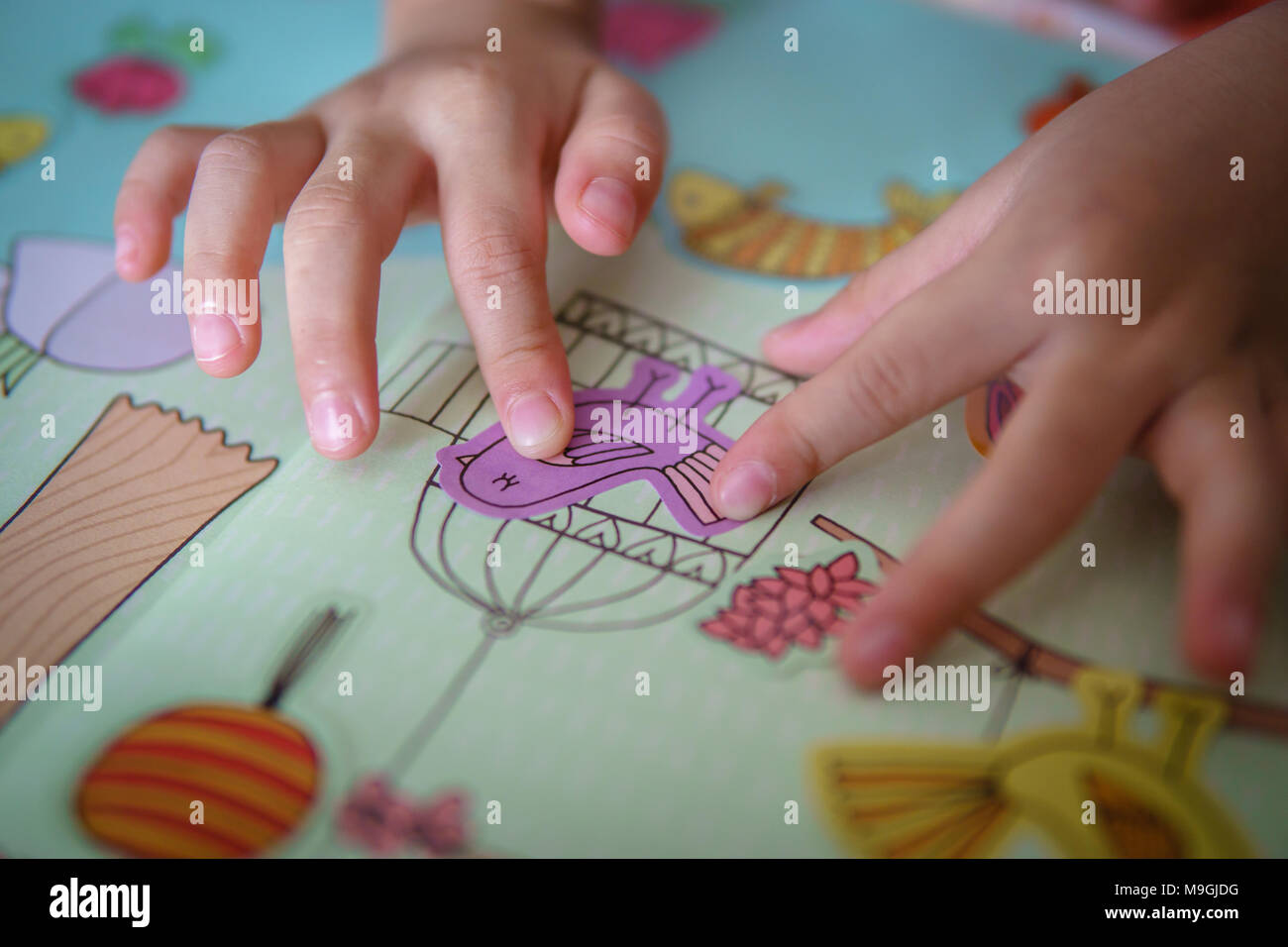 Attività bird cage libro bambino Closeup giorno dito ragazza canto elevato angolo visualizza vacanza imprigionano indoor kid learning persone stick adesivi Foto Stock