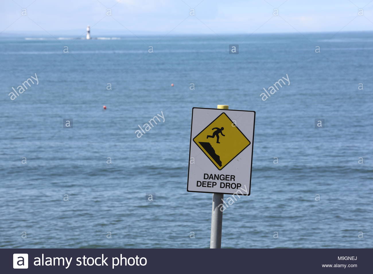 Un pericolo giallo caduta profondo segno avverte la gente contro andando vicino a una ripida scogliera sulla costa occidentale dell'Irlanda. Foto Stock