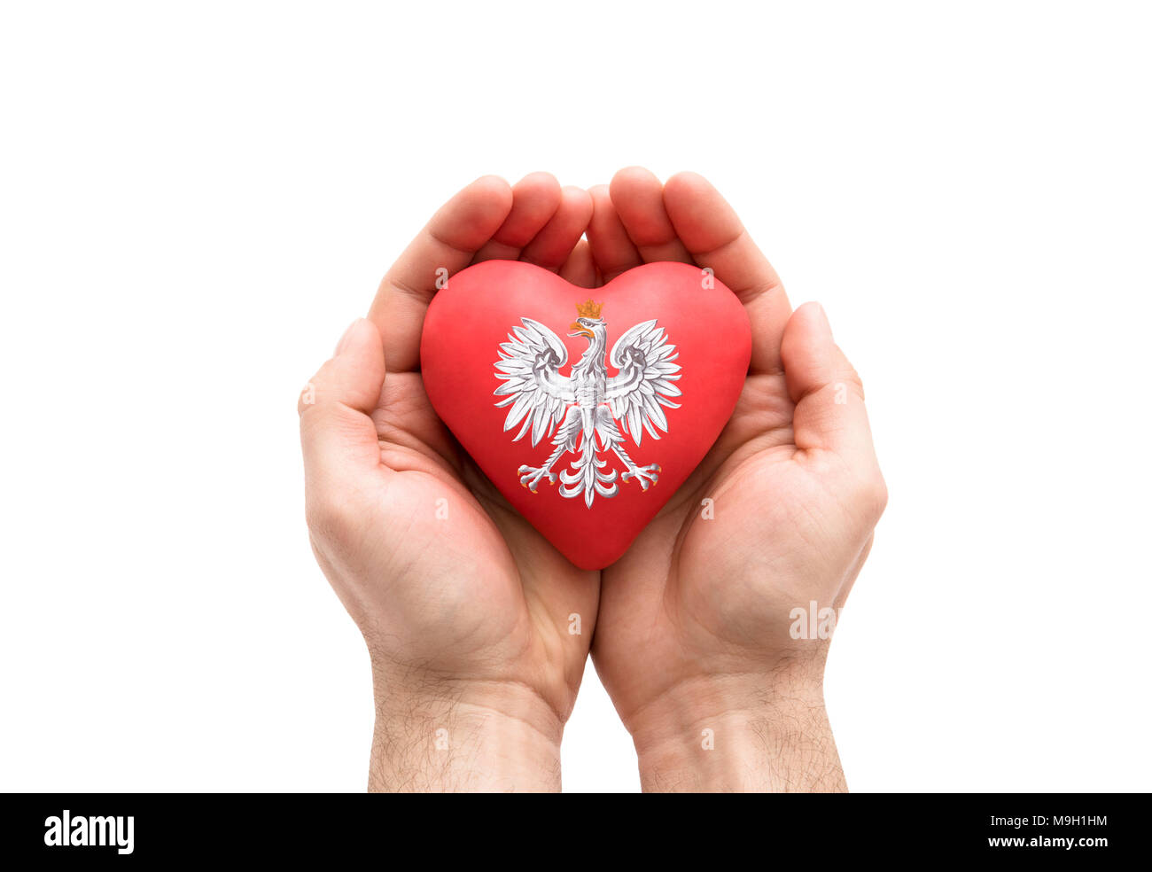 Le mani che coprono il polacco stemma su un cuore rosso isolato su sfondo bianco. Percorso di clipping incluso. Foto Stock