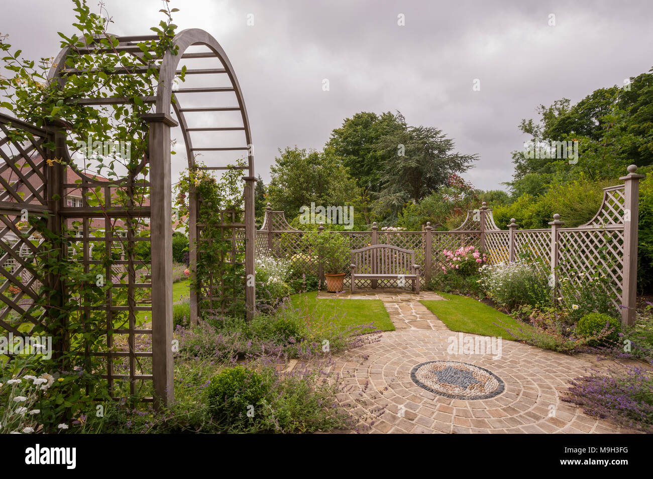 Estate piante, opere d'arte del mosaico, schermata trellis, arbour archway & sedile - bella e tradizionale e paesaggistici, progettato giardino - Yorkshire, Inghilterra, Regno Unito. Foto Stock