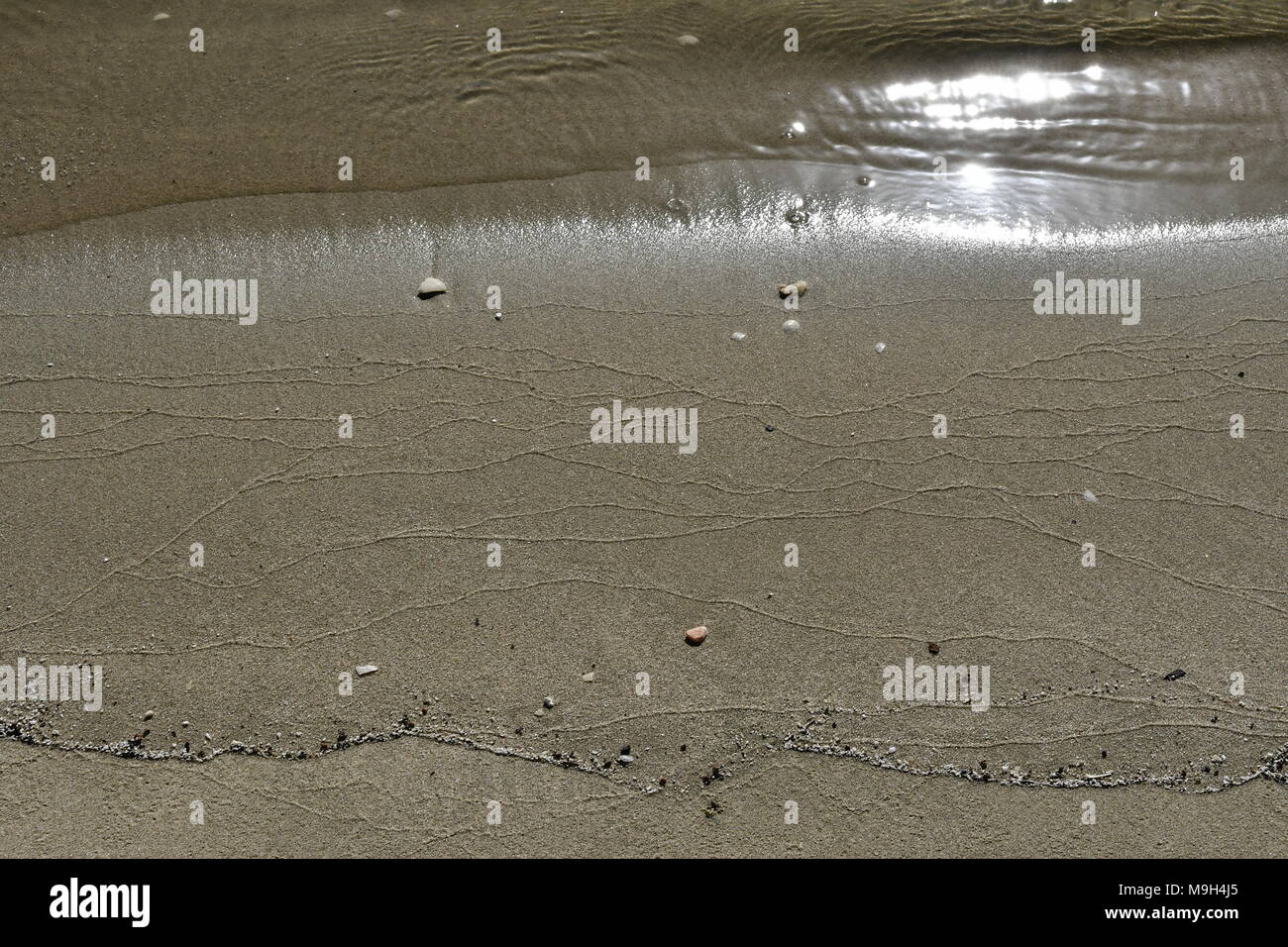 La sabbia e le onde del mare su una spiaggia di sabbia in Dammam Foto Stock