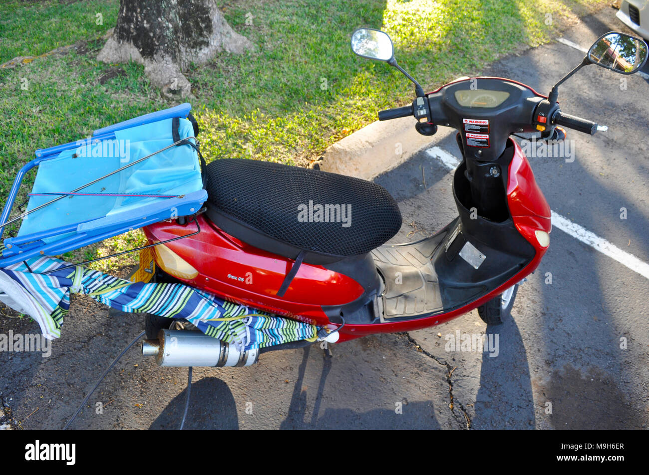 Pronta per la spiaggia. Un piccolo scooter con un ombrellone e sedia attaccato, Maui, Hawaii, STATI UNITI D'AMERICA Foto Stock
