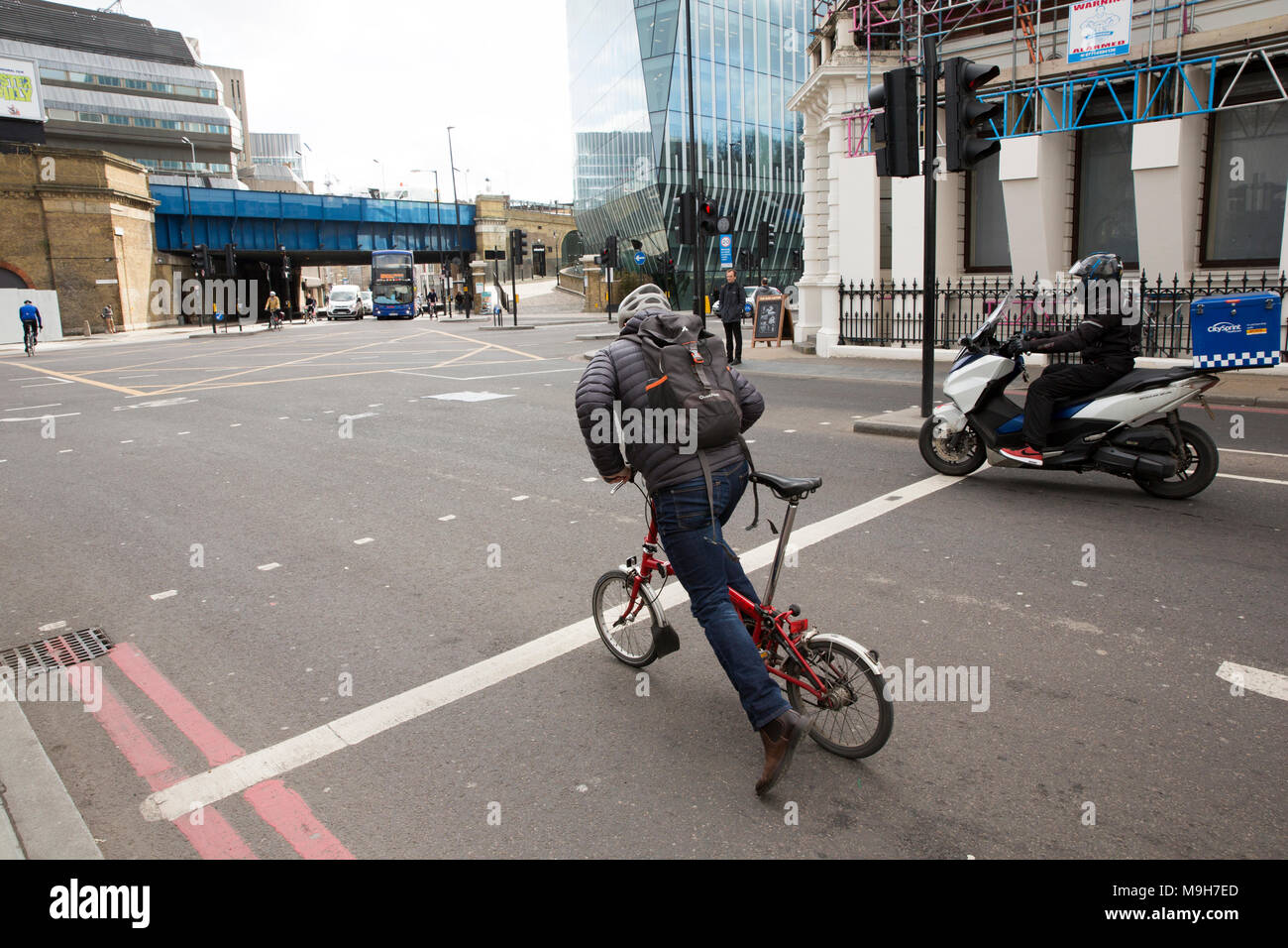 Pilota di un Brompton bicicletta pieghevole in corrispondenza della giunzione di Stamford Street e Blackfriars Bridge a sinistra. London REGNO UNITO Foto Stock