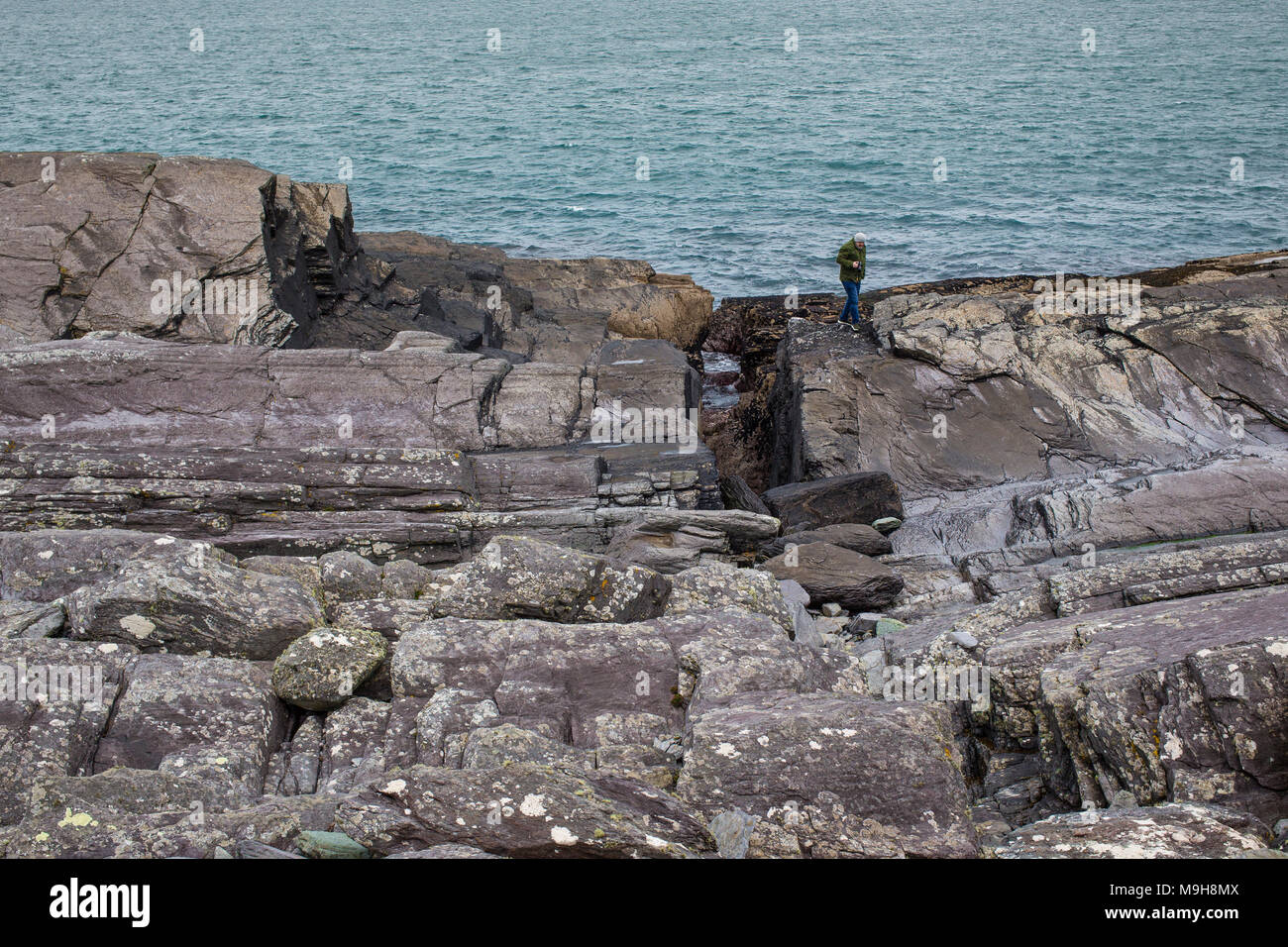 L'uomo sulle rocce Valentia Island, nella contea di Kerry Irlanda Foto Stock