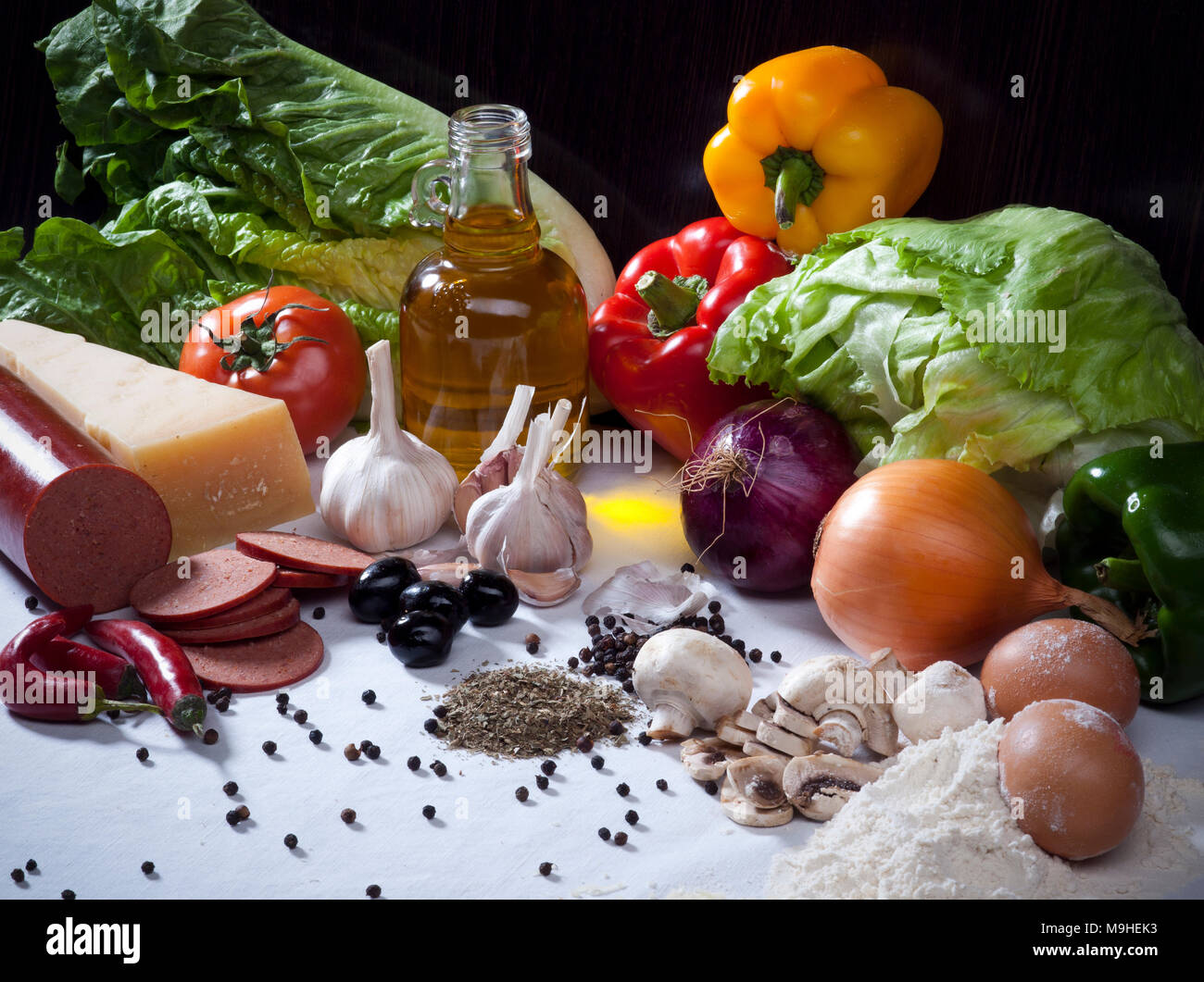 Ortaggi ancora vita composizione con carne, formaggio, uova, spezie, olio di oliva e gli altri ingredienti alimentari Foto Stock