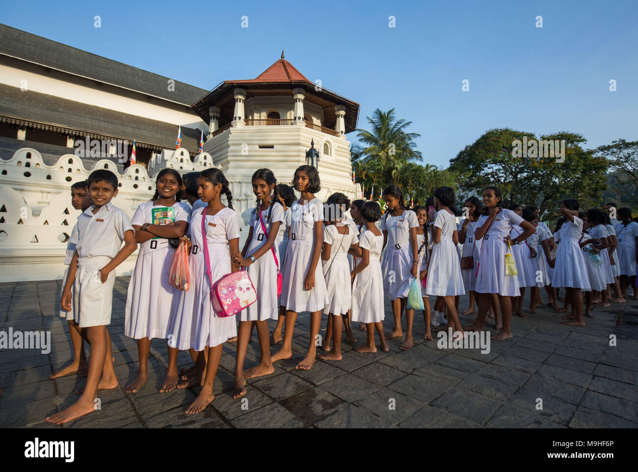 Scuola gli studenti in una coda al di fuori del tempio del Dente, Kandy, Sri Lanka, in Asia. Foto Stock