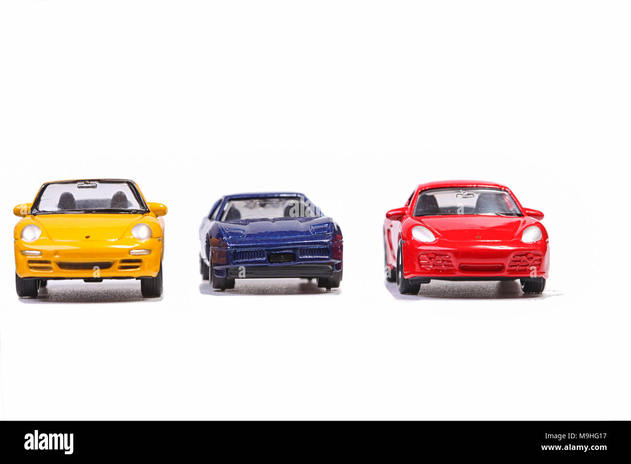 Tre piccole automobili giocattolo su una riga Foto Stock