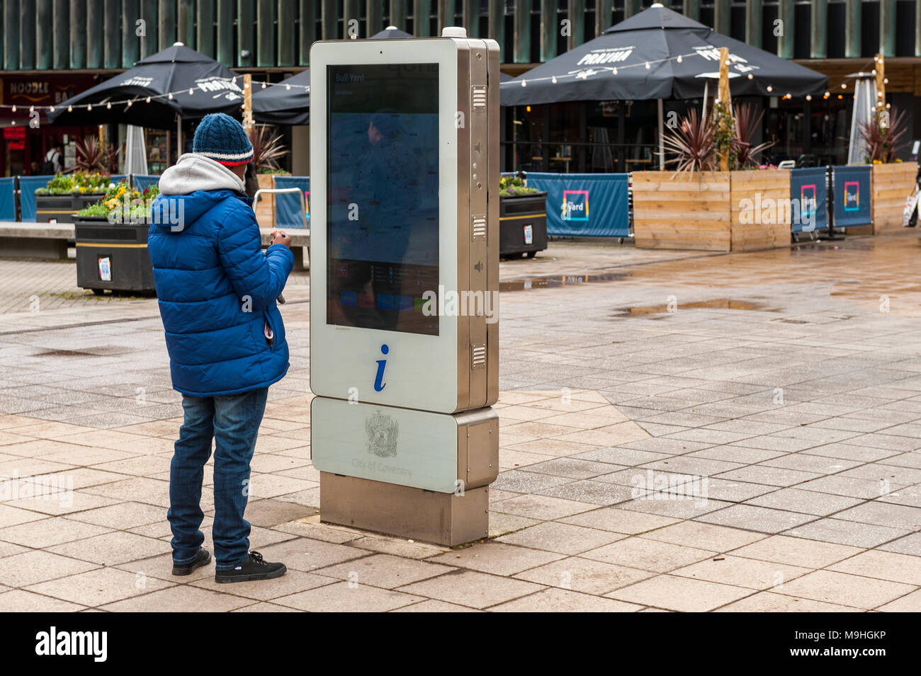 Tourist guarda ad un sistema elettronico di informazione board nel cantiere di Bull, Coventry, West Midlands, Regno Unito. Foto Stock