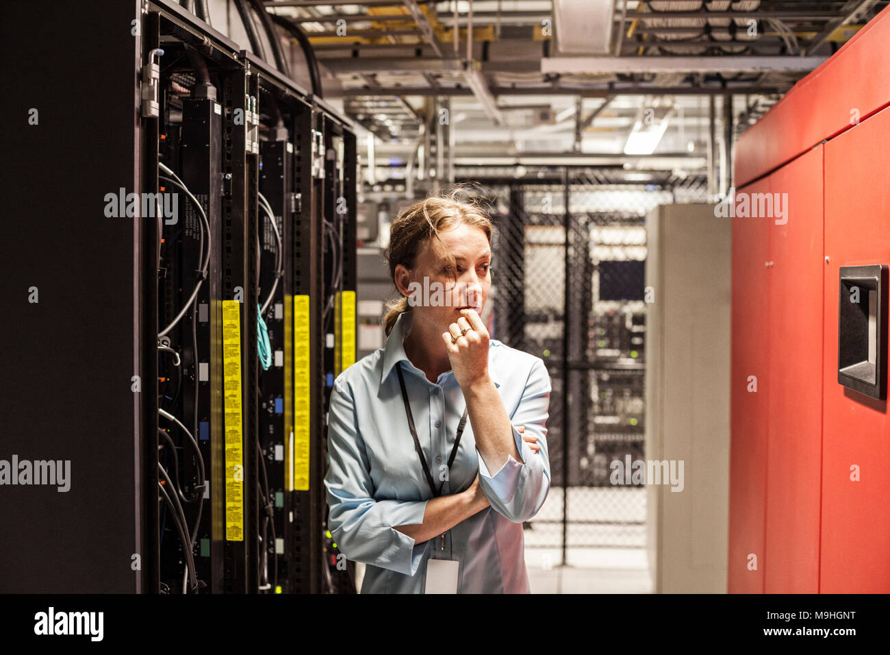 La donna caucasica tecnico che lavora su un computer server in una farm di server. Foto Stock