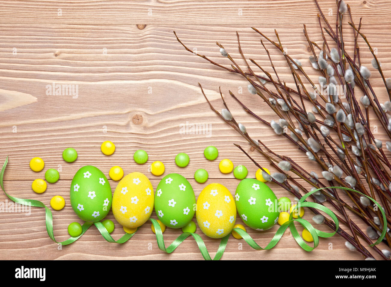 Le uova di pasqua, cioccolatini e i rami di salici su sfondo di legno. Foto Stock