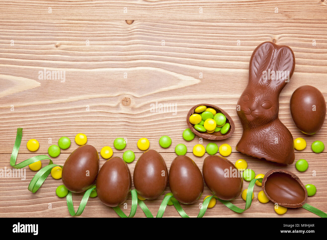 Pasqua uova di cioccolato, bunny e caramelle su sfondo di legno. Foto Stock