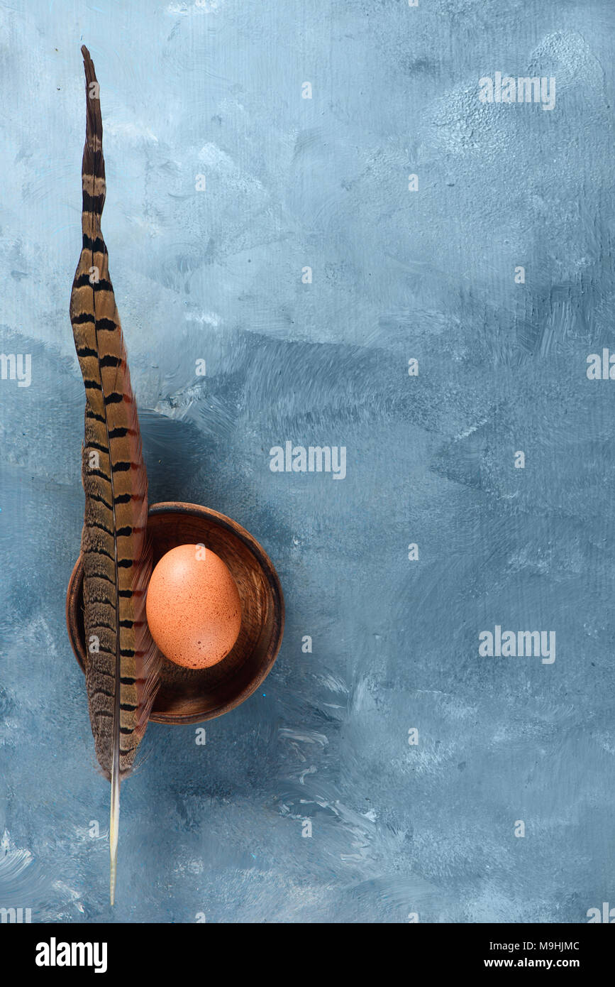 Fresco uova di pollo con una piuma. La cucina minimalista concetto con copia spazio. Foto Stock