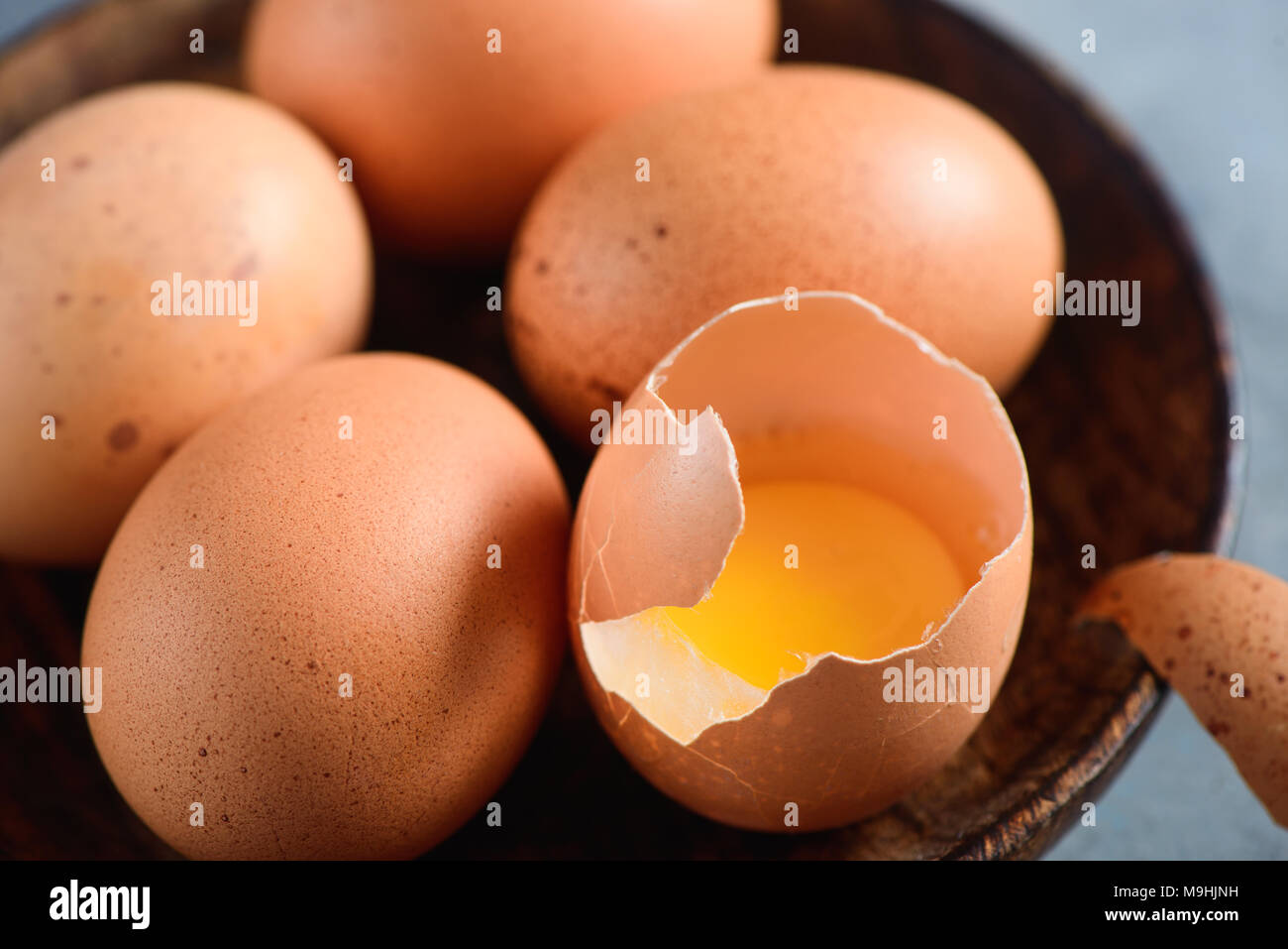 Tuorlo d'uovo in un guscio d'uovo close-up. Materie di cottura Ingredienti sfondo con copia spazio. Moderno concetto di Pasqua marrone con uova di gallina Foto Stock