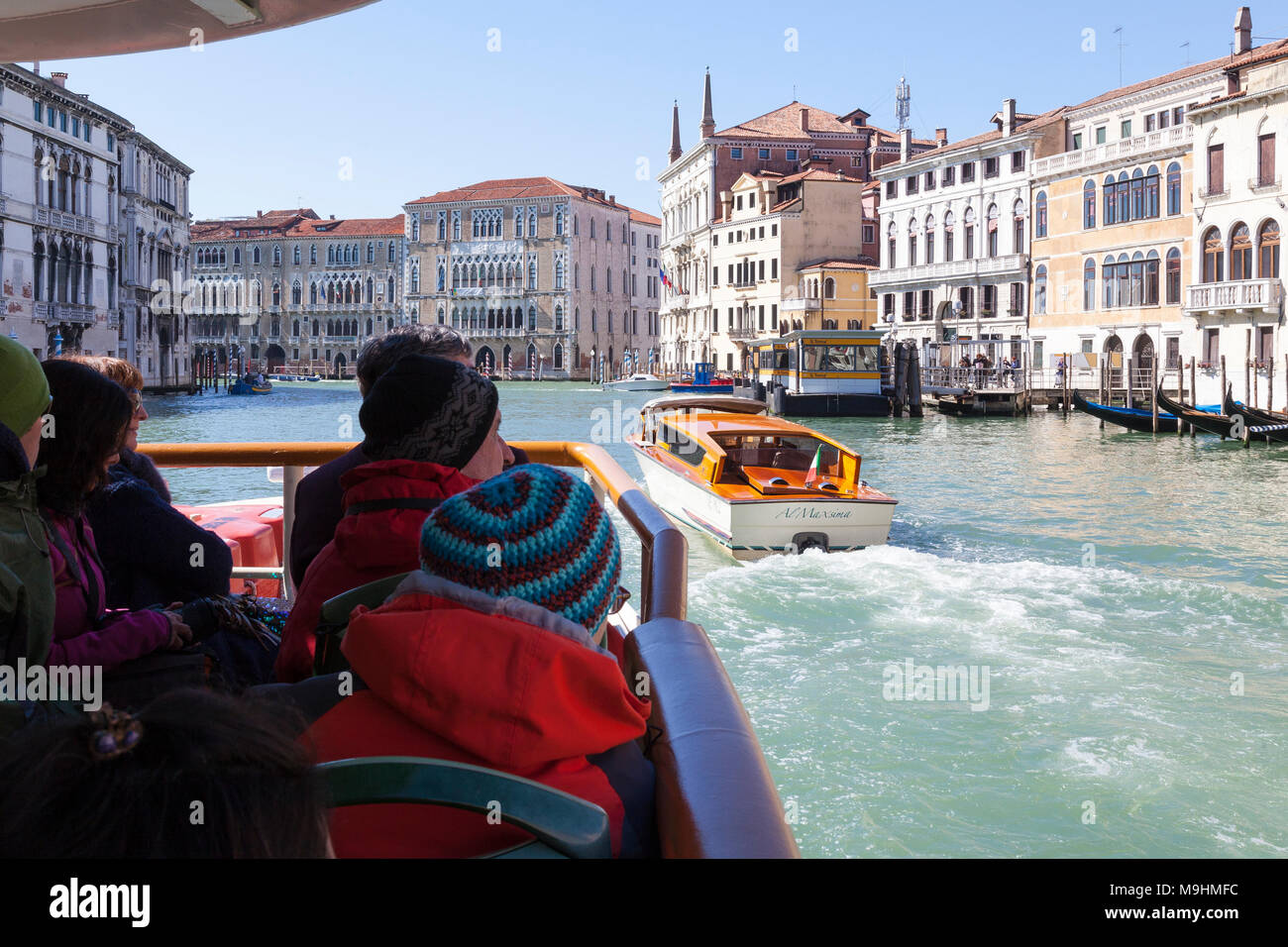 I passeggeri di prima persona POV su un vaporetto vaporetto viaggia verso il basso il Grand Canal, Venezia, Italia verso Università Ca' Foscari con un taxi acqueo p Foto Stock