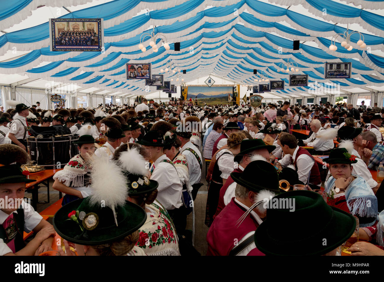 Tradizionale festa tedesca con persone sedute sulle panchine in grande tenda festival Foto Stock