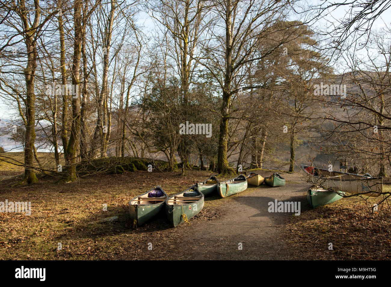 Canoe in attesa sulle rive di Coniston Water nel distretto del lago. Foto Stock