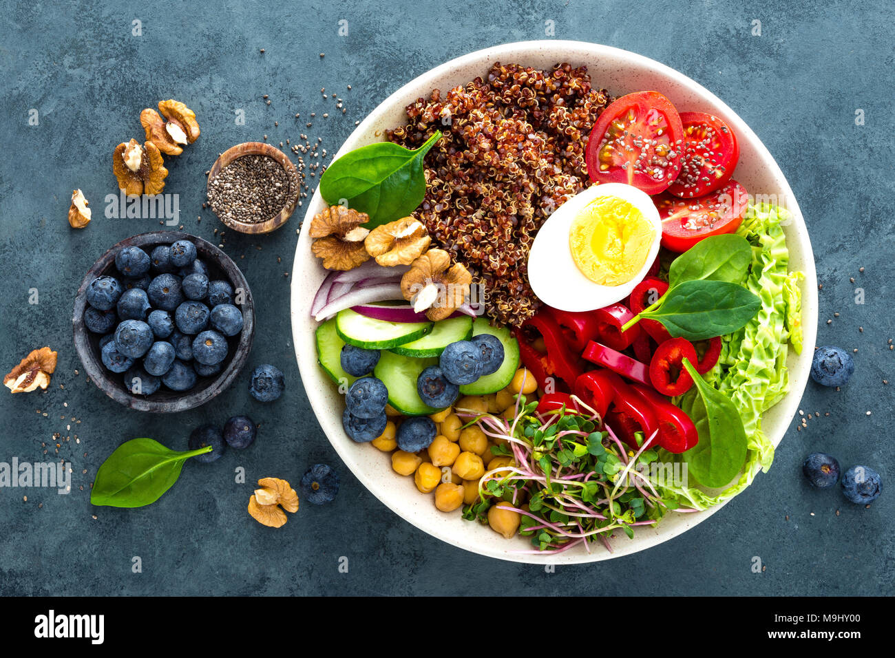 Ciotola di Buddha cena con uova sode, ceci, pomodoro fresco, peperoni, cetrioli, cavolo verza, cipolla rossa, verde i germogli di foglie di spinaci, mirtillo Foto Stock