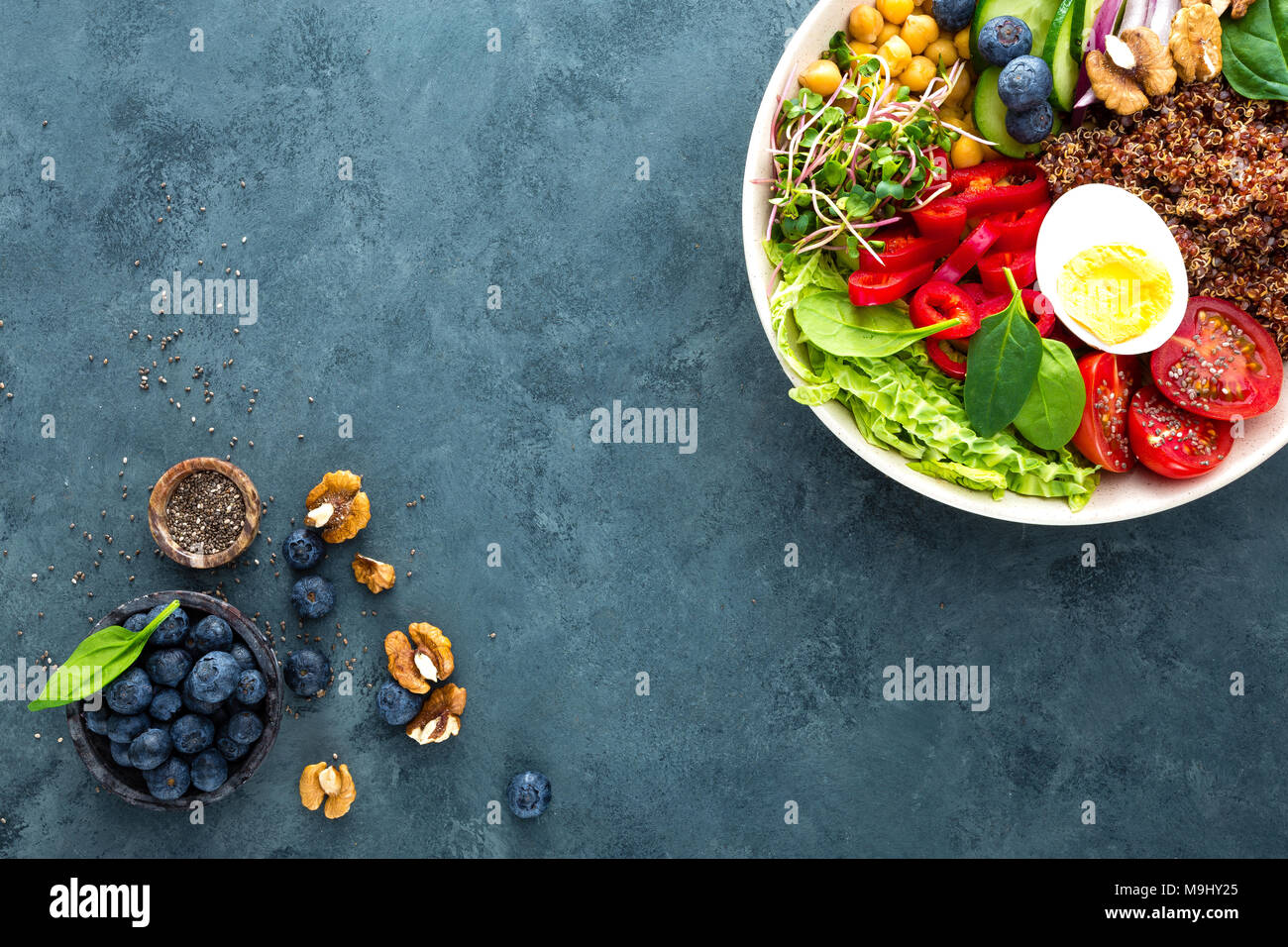 Ciotola di Buddha cena con uova sode, ceci, pomodoro fresco, peperoni, cetrioli, cavolo verza, cipolla rossa, verde i germogli di foglie di spinaci, mirtillo Foto Stock
